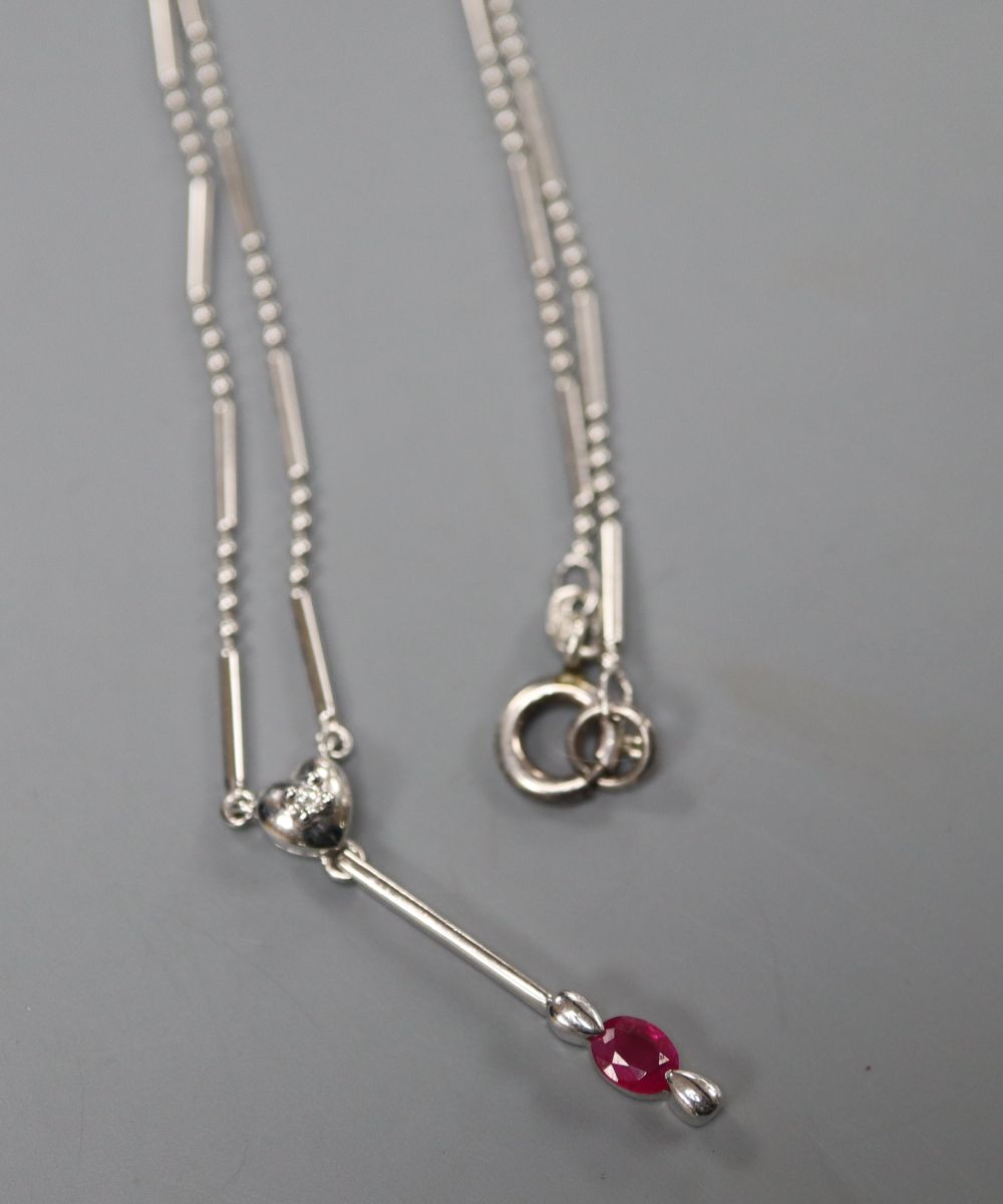An 18ct white gold (750) pendant with ruby drop on bar and long link chain with silver clasp, chain 38cm, gross 4.8 grams.